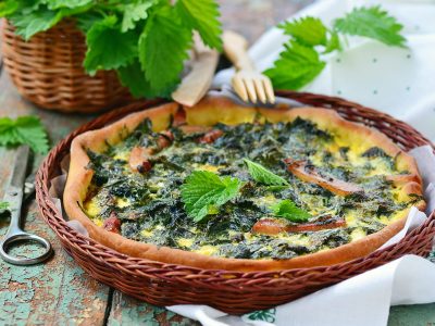 homemade nettle quiche on rustic wooden  background